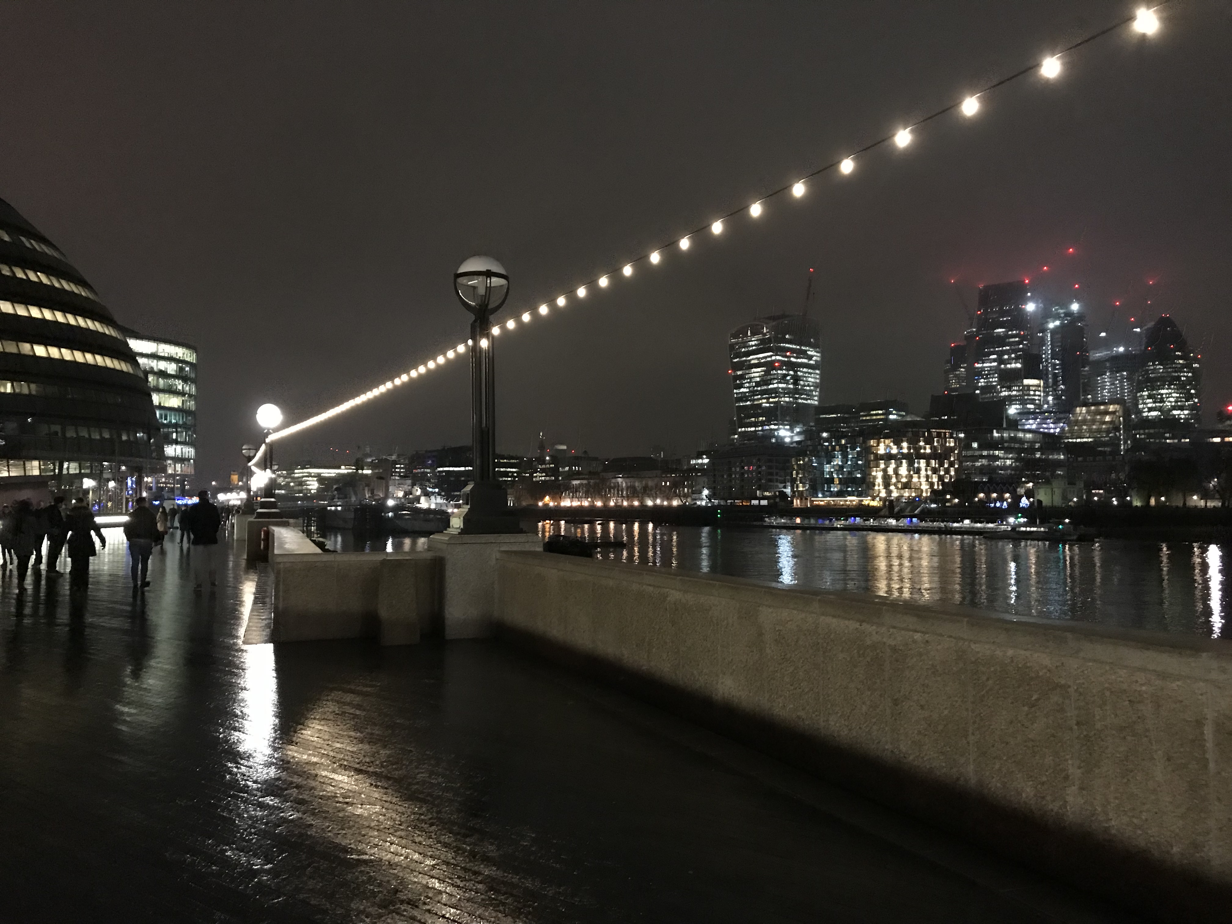 Blick von der Uferpromenade der Themse auf London während eines Rundgangs bei Nacht