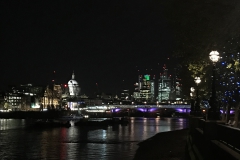Londons Skyline bei Nacht vom Ufer der Themse aus